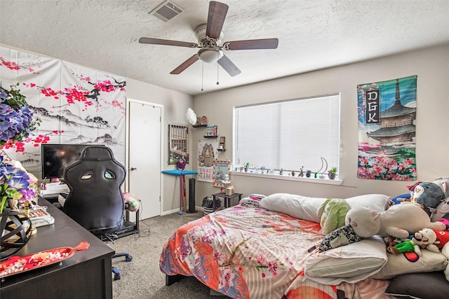 bedroom featuring carpet flooring, ceiling fan, and a textured ceiling