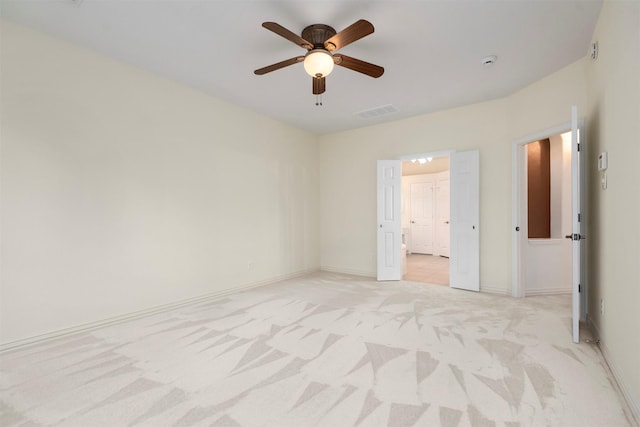 empty room featuring ceiling fan and light colored carpet