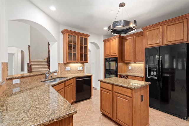 kitchen featuring sink, hanging light fixtures, tasteful backsplash, kitchen peninsula, and black appliances