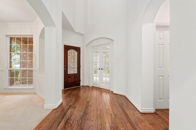 foyer entrance featuring hardwood / wood-style flooring, french doors, and ornamental molding