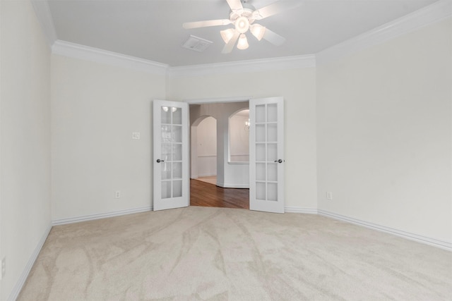 carpeted spare room featuring crown molding, french doors, and ceiling fan