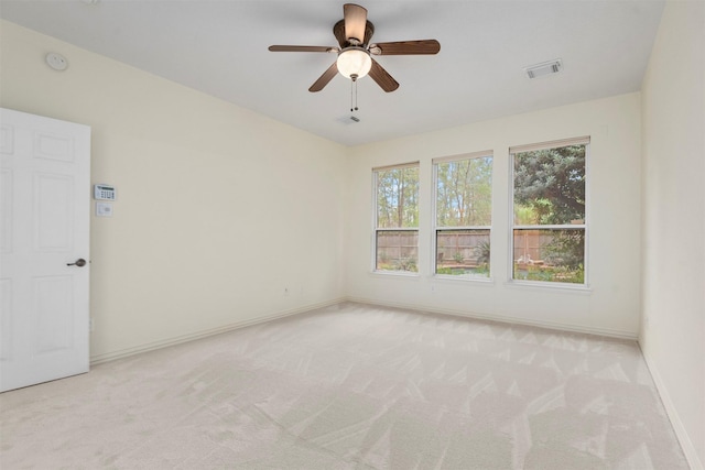 empty room with ceiling fan and light carpet