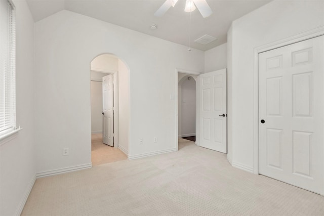 unfurnished bedroom featuring ceiling fan, lofted ceiling, light carpet, and a closet