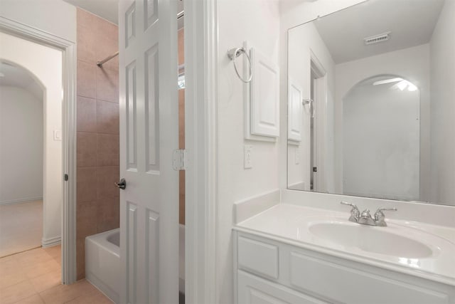 bathroom with tile patterned flooring, vanity, and tiled shower / bath combo