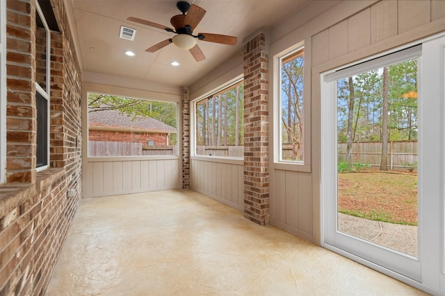 unfurnished sunroom featuring ceiling fan