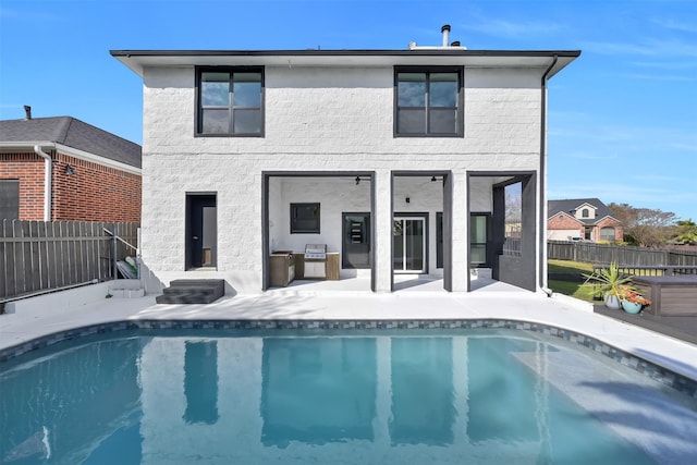 rear view of house with a fenced in pool