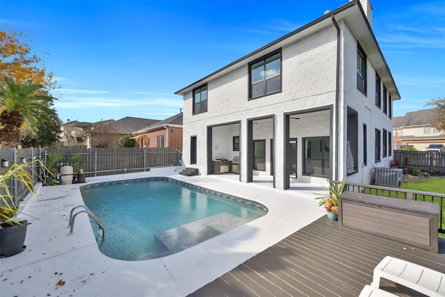 view of swimming pool with central AC unit and a wooden deck