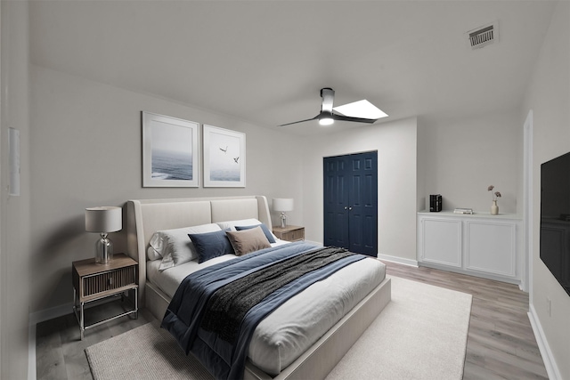 bedroom featuring ceiling fan, a closet, and light hardwood / wood-style floors