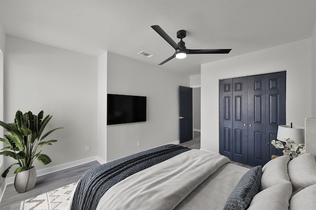 bedroom featuring ceiling fan, a closet, and wood-type flooring