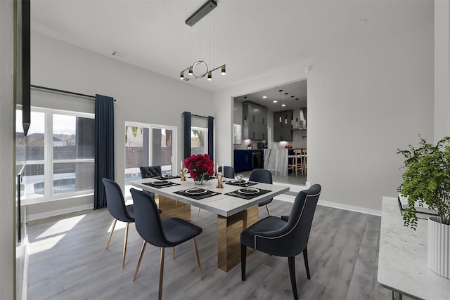 dining area with light hardwood / wood-style flooring and a notable chandelier