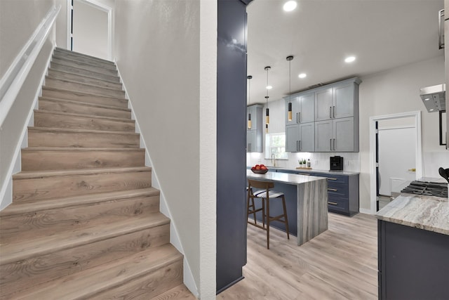 stairway featuring sink and wood-type flooring