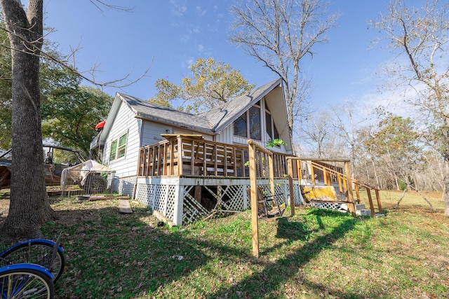 rear view of house with a yard and a wooden deck