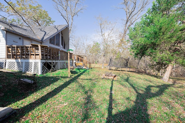 view of yard featuring a deck and a trampoline