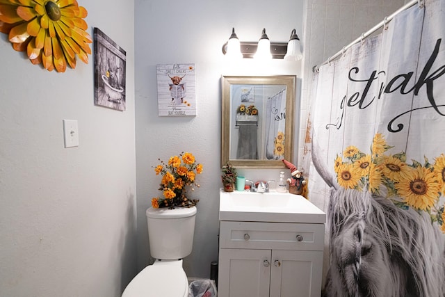 bathroom with a shower with curtain, vanity, and toilet