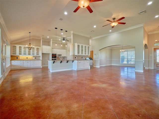 unfurnished living room with ceiling fan with notable chandelier, vaulted ceiling, and ornamental molding