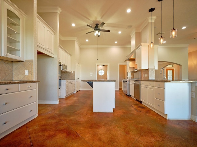 kitchen with backsplash, hanging light fixtures, ceiling fan, light stone countertops, and white cabinetry