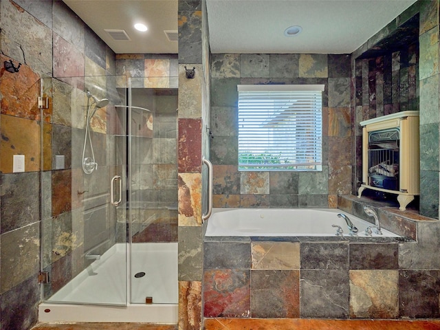 bathroom featuring shower with separate bathtub and tile walls