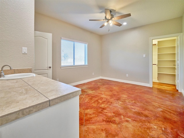 interior space featuring ceiling fan and sink