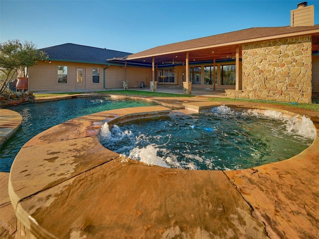 view of swimming pool featuring an in ground hot tub and a patio