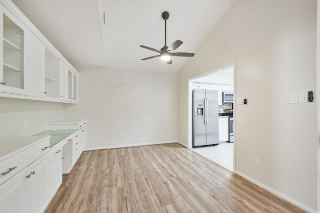 interior space with ceiling fan, lofted ceiling, and light hardwood / wood-style flooring