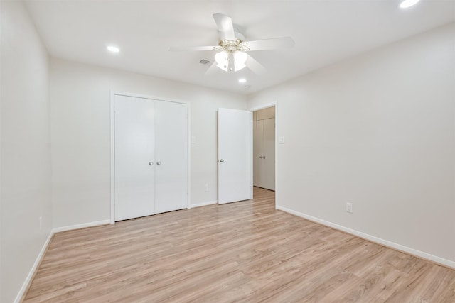 unfurnished bedroom with a closet, light hardwood / wood-style floors, and ceiling fan