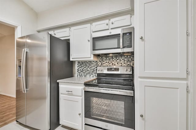 kitchen featuring white cabinets, appliances with stainless steel finishes, and decorative backsplash