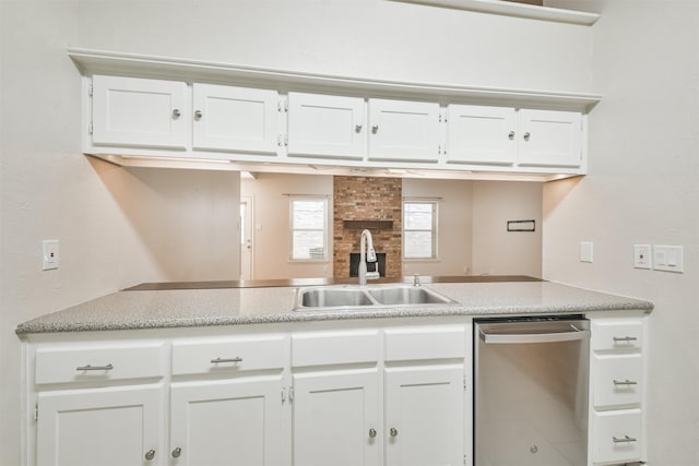 kitchen with dishwasher, white cabinets, and sink