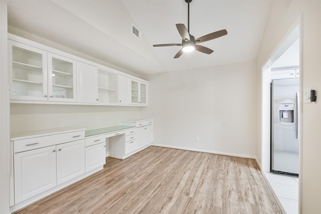 kitchen featuring white cabinets, ceiling fan, built in desk, light wood-type flooring, and stainless steel fridge with ice dispenser