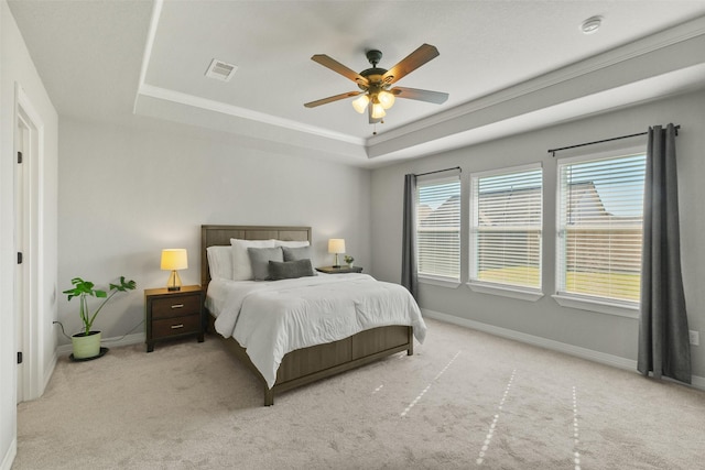 bedroom featuring ceiling fan, a raised ceiling, light carpet, and crown molding