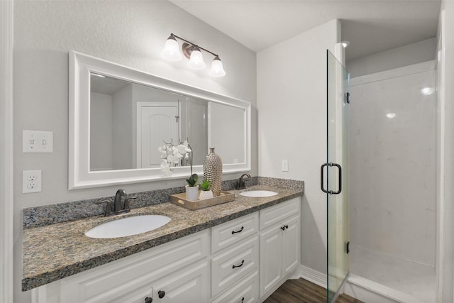 bathroom with hardwood / wood-style flooring, vanity, and walk in shower