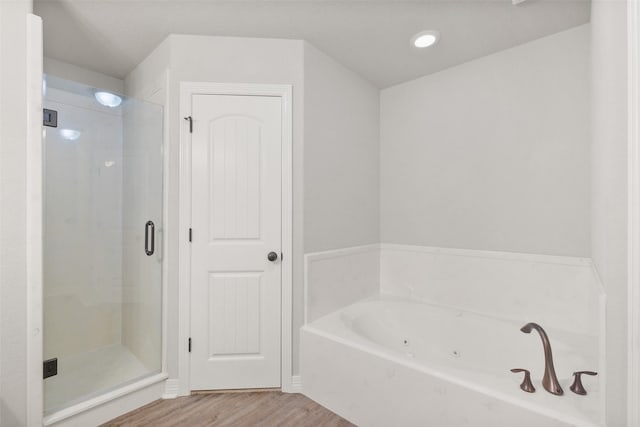 bathroom with hardwood / wood-style flooring and separate shower and tub