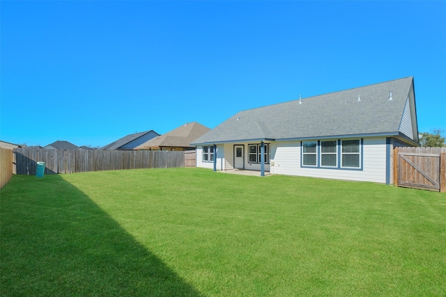 back of house with a patio area and a yard