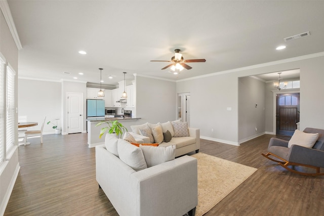 living room featuring dark hardwood / wood-style floors, ceiling fan, crown molding, and a wealth of natural light