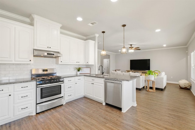 kitchen featuring pendant lighting, white cabinets, stainless steel appliances, and extractor fan