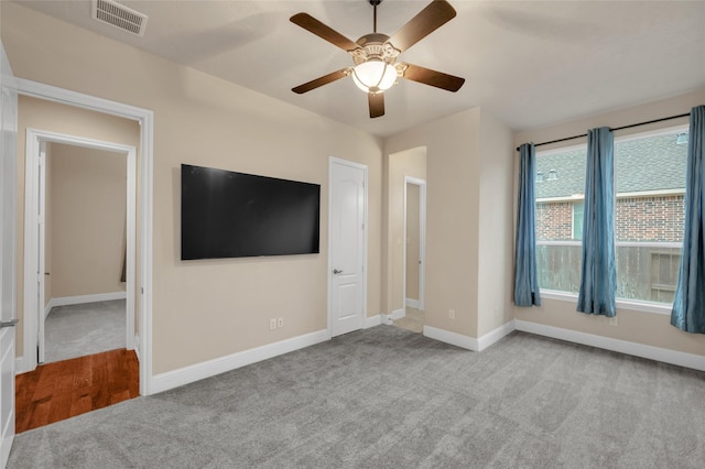 unfurnished living room featuring ceiling fan and light colored carpet