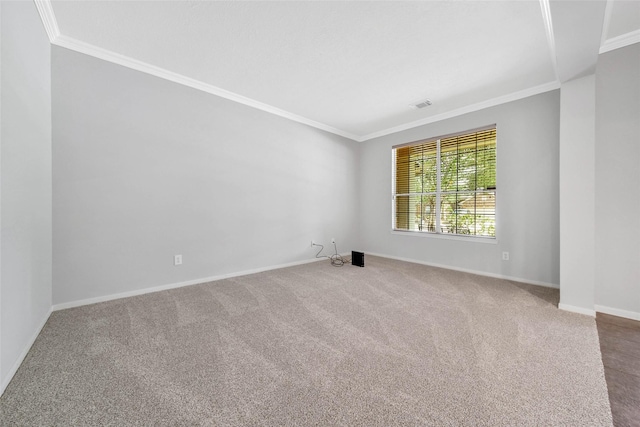 carpeted spare room with baseboards, visible vents, and ornamental molding