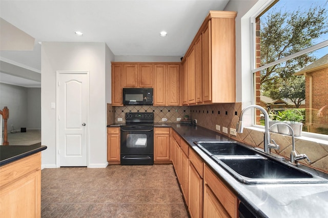 kitchen featuring baseboards, decorative backsplash, dark countertops, black appliances, and a sink