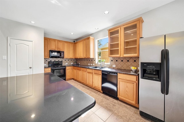 kitchen featuring black appliances, backsplash, light tile patterned floors, and sink