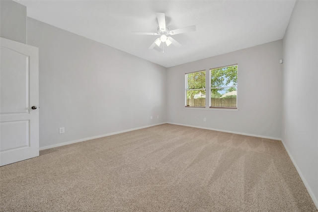 carpeted empty room featuring ceiling fan and baseboards