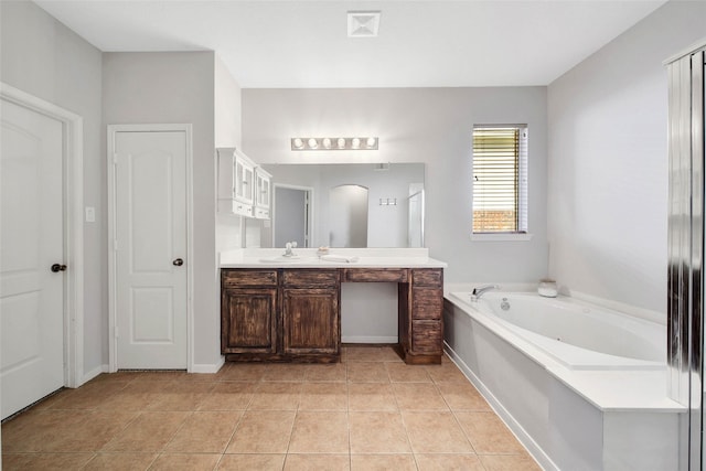 bathroom with a garden tub, a closet, vanity, baseboards, and tile patterned floors