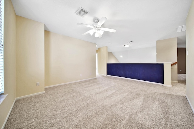 unfurnished room with lofted ceiling, carpet, visible vents, and baseboards