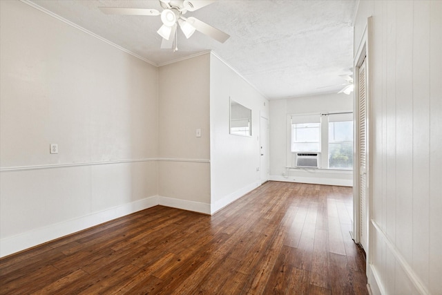 unfurnished room featuring cooling unit, dark hardwood / wood-style floors, ceiling fan, ornamental molding, and a textured ceiling