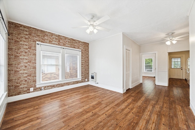 spare room featuring heating unit, dark hardwood / wood-style floors, ornamental molding, and ceiling fan