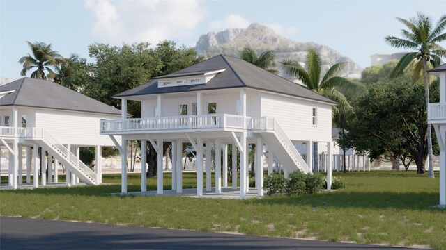 back of house featuring a mountain view, a porch, and a yard