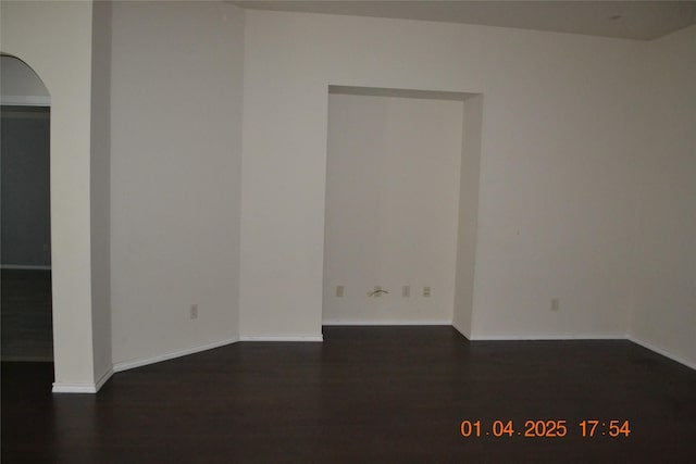 empty room with dark hardwood / wood-style flooring