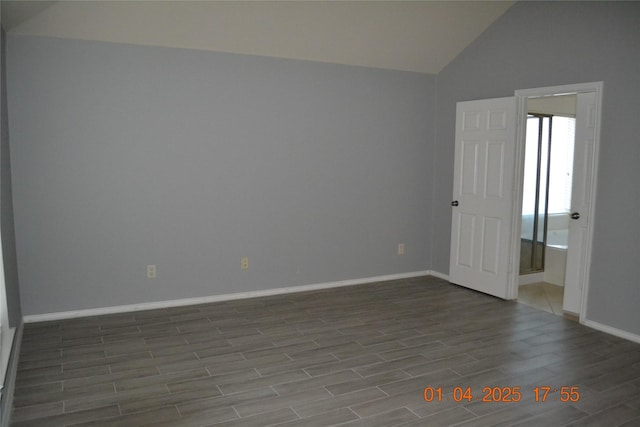 spare room featuring hardwood / wood-style flooring and vaulted ceiling