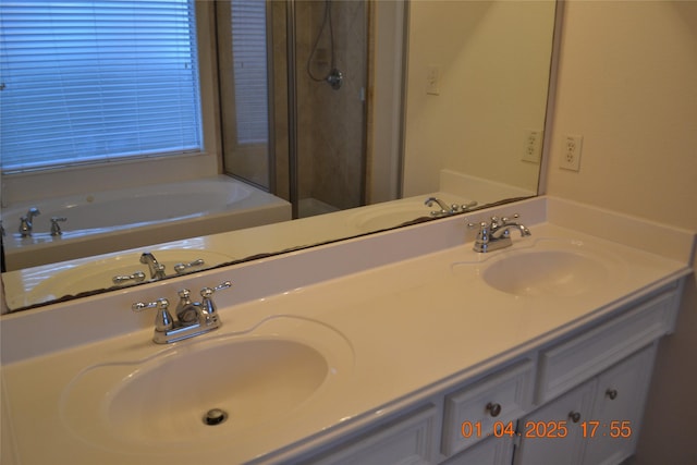 bathroom featuring vanity and independent shower and bath