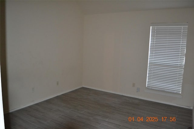 unfurnished room with dark wood-type flooring