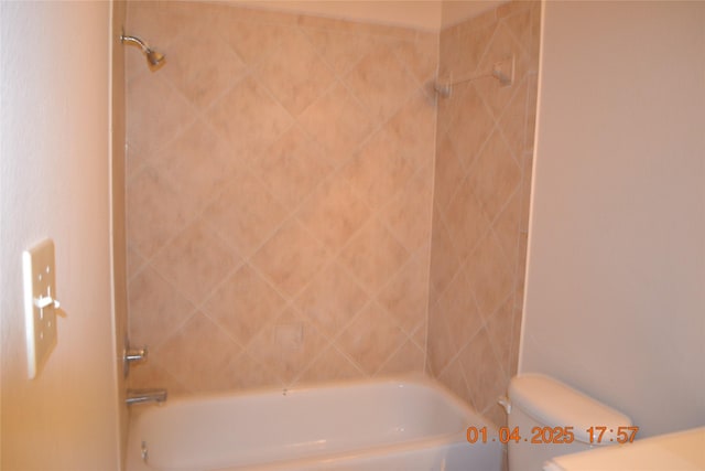 bathroom featuring tiled shower / bath and toilet