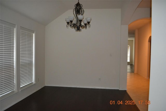 unfurnished dining area featuring an inviting chandelier and lofted ceiling